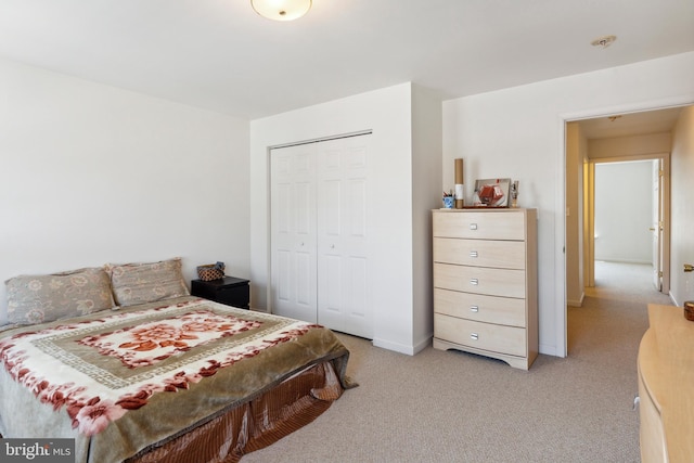 bedroom featuring a closet and light colored carpet