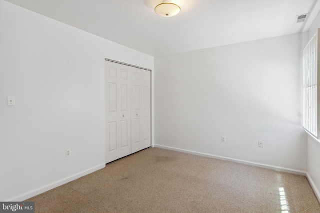 unfurnished bedroom featuring a closet and carpet floors