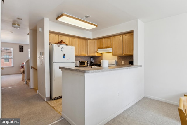 kitchen with light carpet, white appliances, tasteful backsplash, and kitchen peninsula