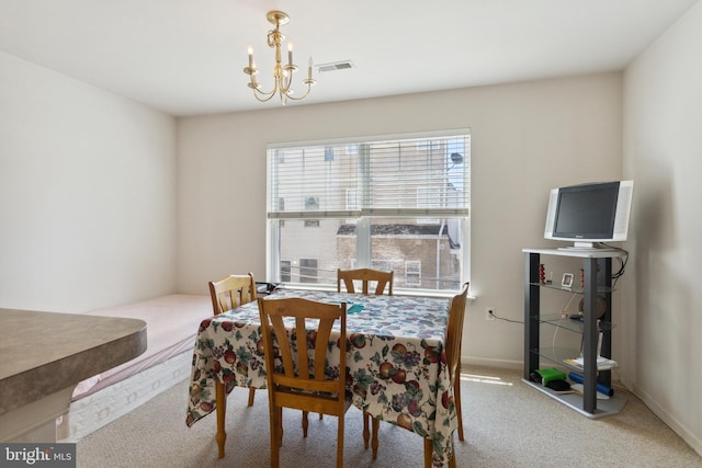 dining area featuring a notable chandelier and light carpet