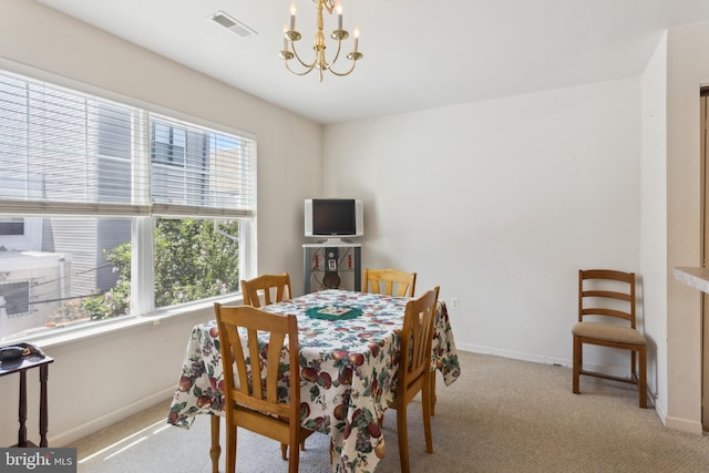 dining room with light colored carpet and a notable chandelier