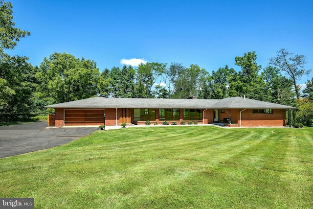 ranch-style house featuring a garage and a front yard