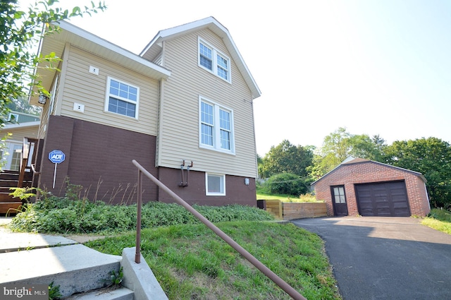 view of front facade featuring driveway, a garage, and an outdoor structure