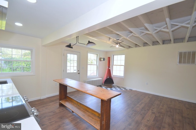 unfurnished office with dark wood-type flooring, a healthy amount of sunlight, visible vents, and baseboards