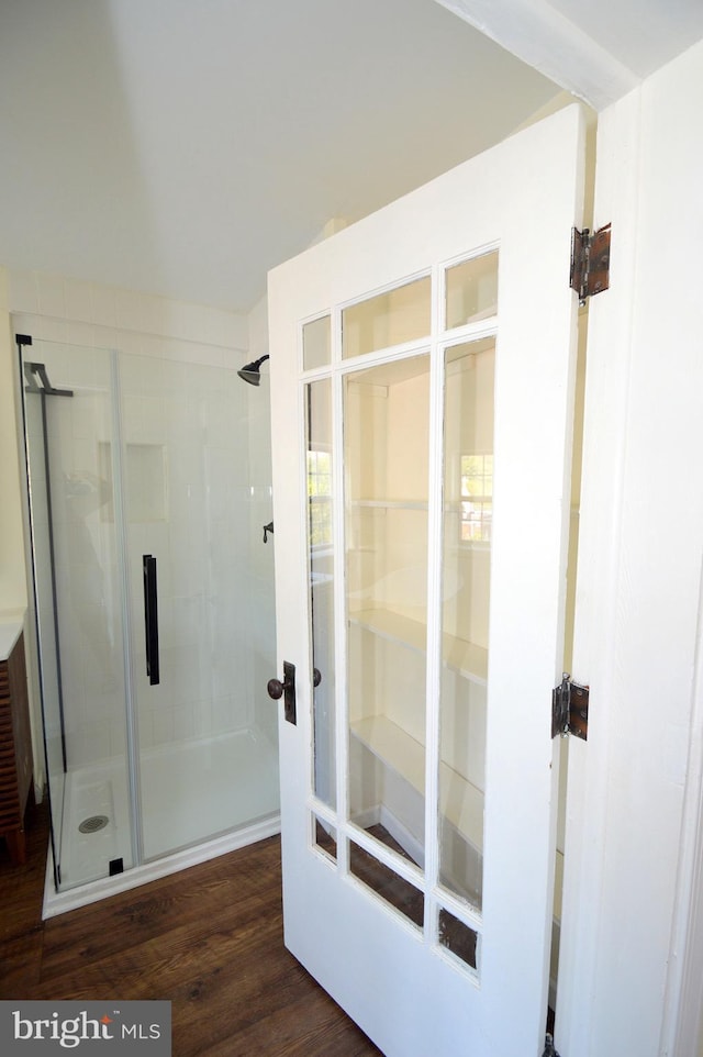 bathroom featuring a shower stall and wood finished floors