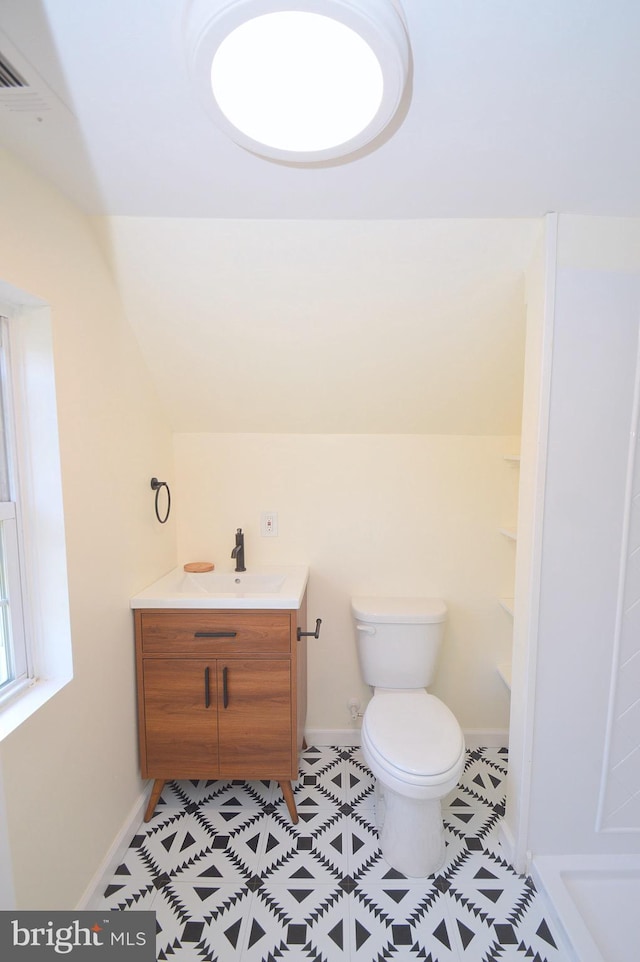 bathroom with toilet, tile patterned floors, baseboards, and vanity