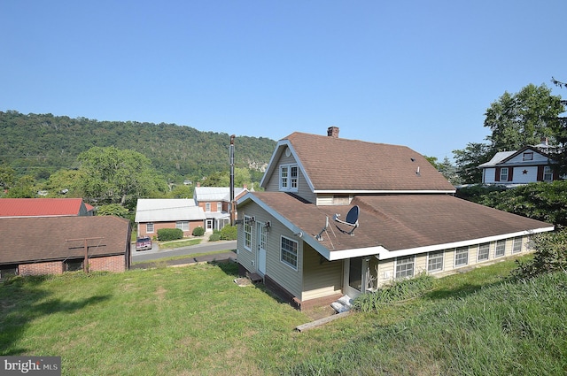 view of property exterior with a chimney and a yard