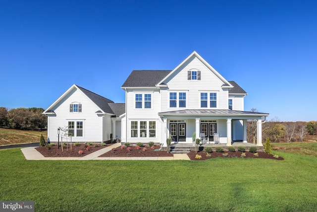 rear view of property featuring a lawn and covered porch