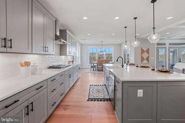 kitchen featuring appliances with stainless steel finishes, light countertops, gray cabinetry, light wood-type flooring, and backsplash