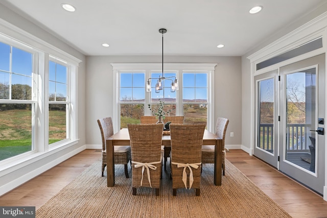 dining area featuring a wealth of natural light, light wood-style flooring, and baseboards