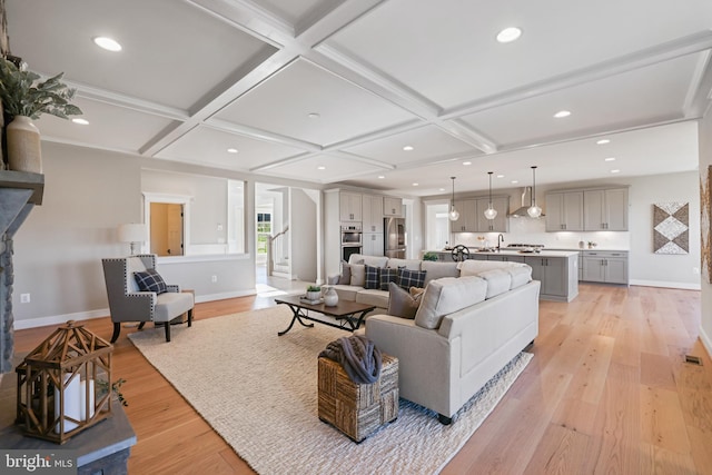 living room featuring recessed lighting, coffered ceiling, light wood-style flooring, and baseboards