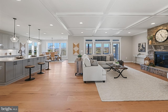 living room with light wood finished floors, baseboards, coffered ceiling, a fireplace, and recessed lighting