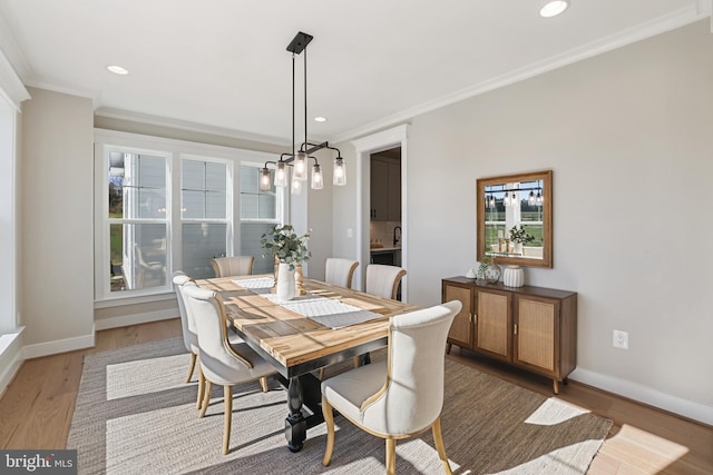 dining area featuring recessed lighting, crown molding, baseboards, and wood finished floors