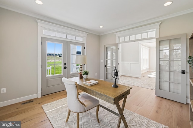 office with light wood finished floors, visible vents, ornamental molding, and french doors