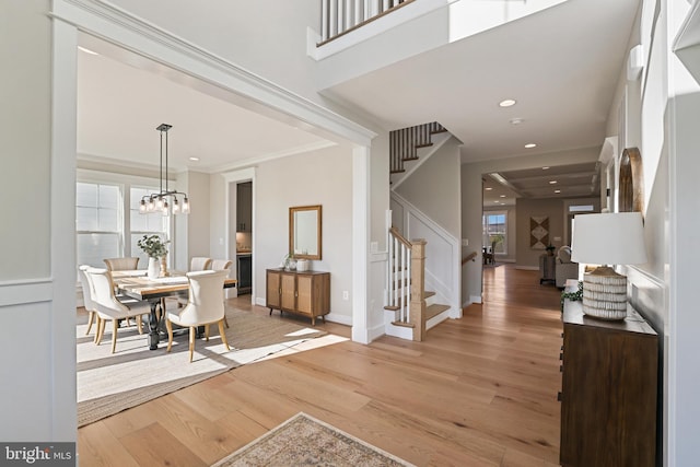 foyer featuring baseboards, light wood-style flooring, stairway, crown molding, and recessed lighting