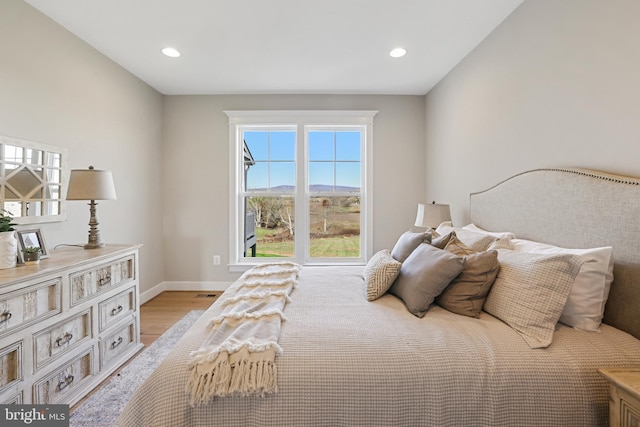 bedroom featuring light wood finished floors, recessed lighting, and baseboards