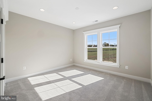 carpeted spare room featuring visible vents, baseboards, and recessed lighting