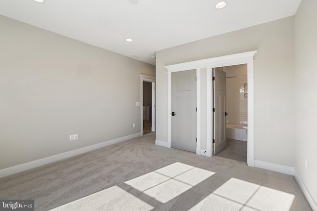 unfurnished bedroom with carpet floors, recessed lighting, ensuite bath, and baseboards