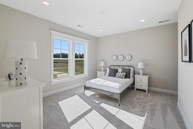 bedroom featuring light carpet, visible vents, and baseboards