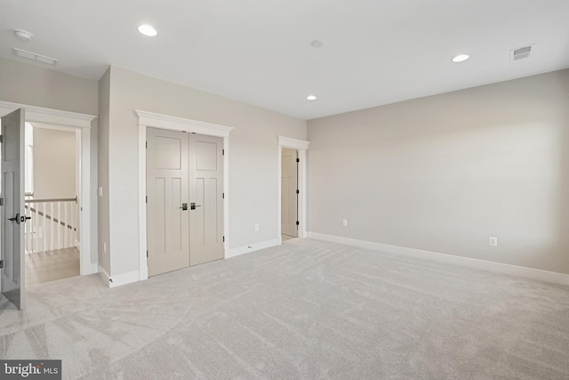 unfurnished bedroom with recessed lighting, visible vents, light carpet, and baseboards