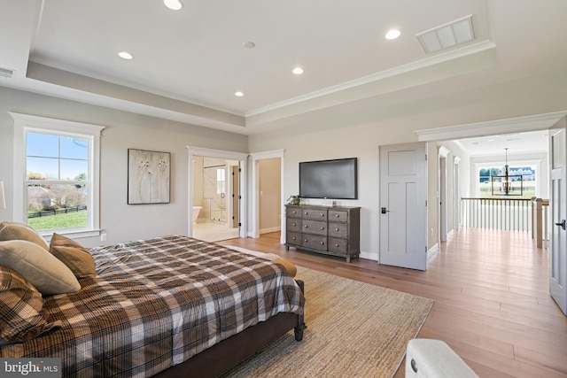 bedroom with visible vents, a tray ceiling, light wood-style flooring, and recessed lighting