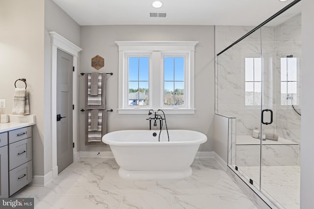 full bathroom with marble finish floor, baseboards, visible vents, and a freestanding tub