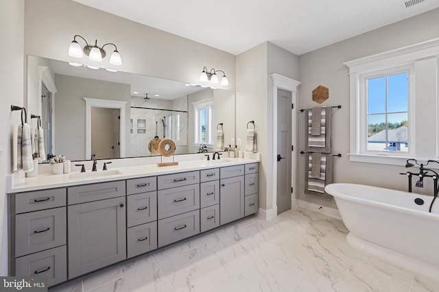 full bathroom with a freestanding bath, marble finish floor, double vanity, and a stall shower