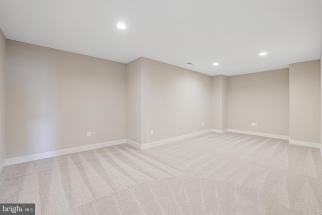 spare room featuring recessed lighting, baseboards, and light colored carpet