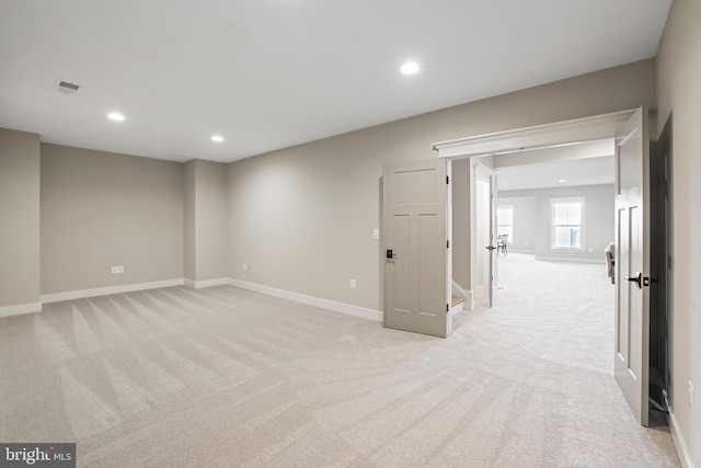 spare room with recessed lighting, light carpet, and baseboards