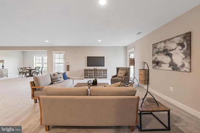 living room with recessed lighting, light colored carpet, visible vents, and baseboards