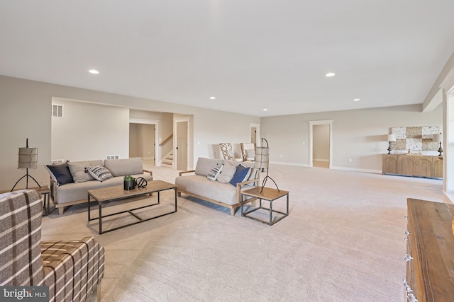 living area featuring recessed lighting, visible vents, light carpet, baseboards, and stairs