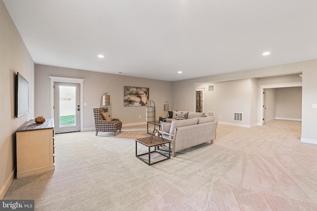 living area featuring recessed lighting, visible vents, baseboards, and light colored carpet