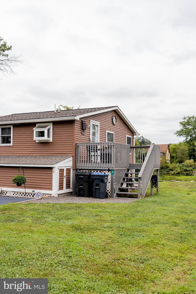 rear view of house with a yard and a wooden deck