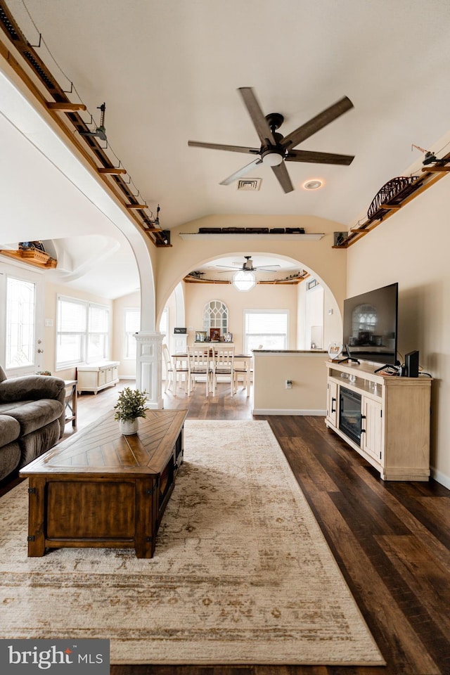 living room with lofted ceiling, ceiling fan, and dark hardwood / wood-style flooring