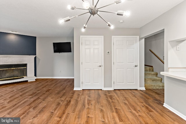 unfurnished living room featuring a brick fireplace and hardwood / wood-style floors