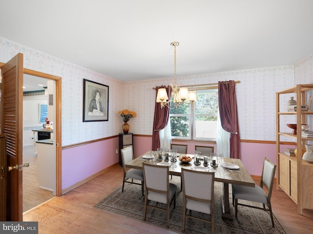 dining area featuring light hardwood / wood-style flooring and an inviting chandelier