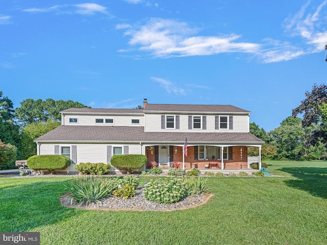 view of front of home with covered porch and a front lawn