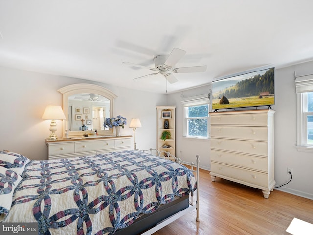 bedroom with multiple windows, ceiling fan, and light hardwood / wood-style floors