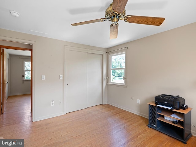 bedroom with ceiling fan, a closet, and light hardwood / wood-style floors