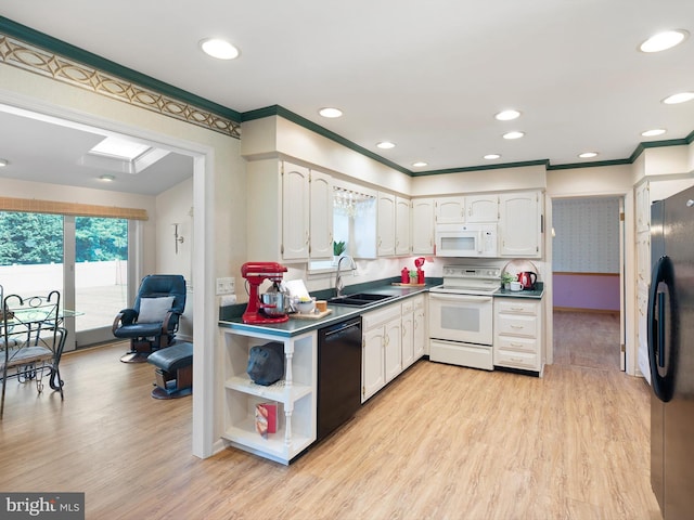 kitchen with black appliances, sink, white cabinets, and light hardwood / wood-style flooring