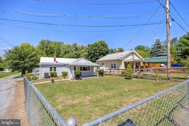 bungalow featuring a front lawn, a chimney, central AC unit, and fence private yard