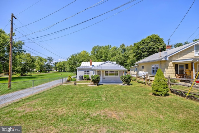 bungalow featuring metal roof, a front yard, and a fenced backyard