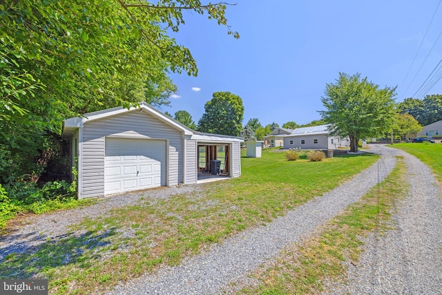 view of front facade with a garage, a front yard, an outdoor structure, and driveway