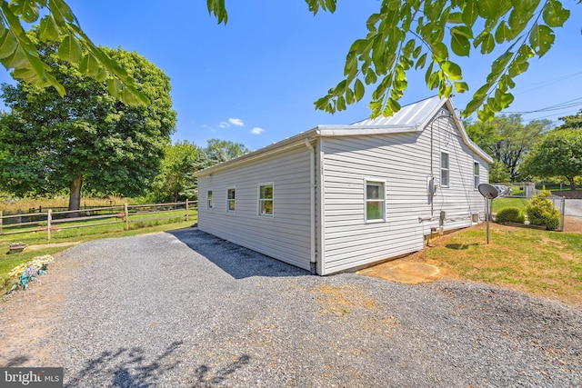 view of home's exterior with driveway and fence