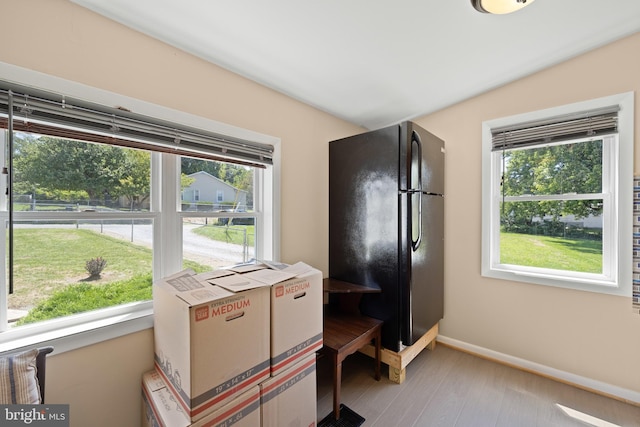 bedroom featuring black refrigerator and light hardwood / wood-style flooring