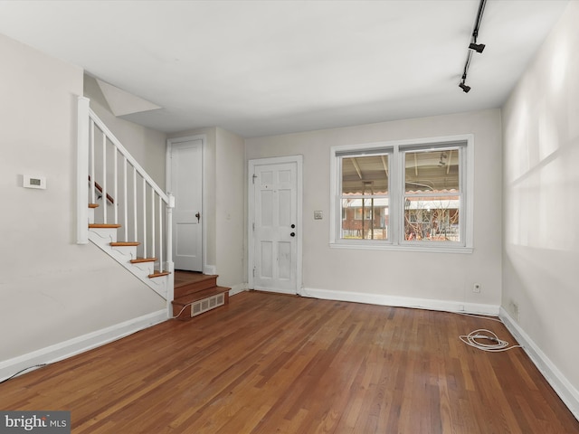 entrance foyer featuring stairs, visible vents, baseboards, and wood finished floors