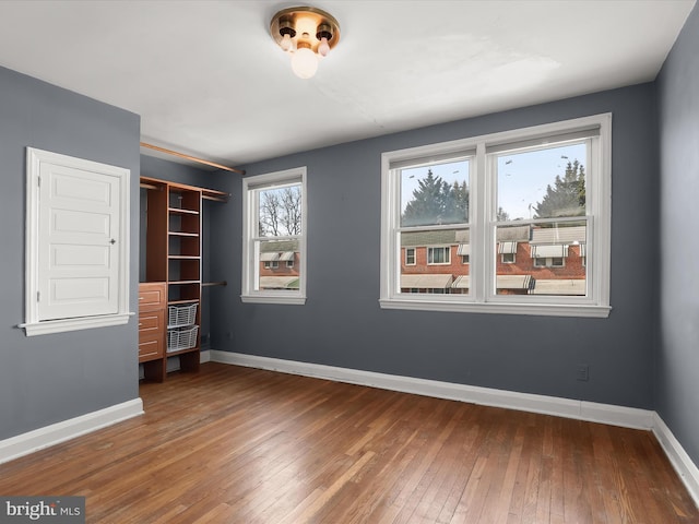 unfurnished bedroom with wood-type flooring and baseboards