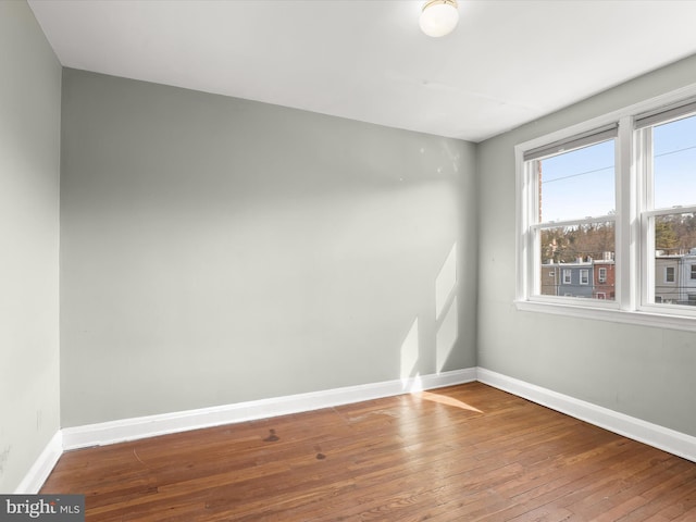 empty room featuring hardwood / wood-style flooring and baseboards