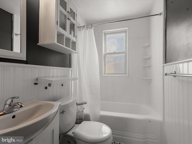 bathroom featuring a wainscoted wall, vanity, toilet, and shower / bathtub combination with curtain