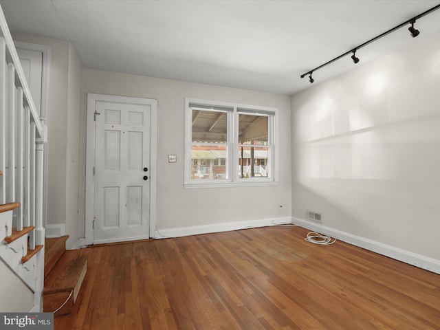 foyer featuring stairs, hardwood / wood-style flooring, visible vents, and baseboards